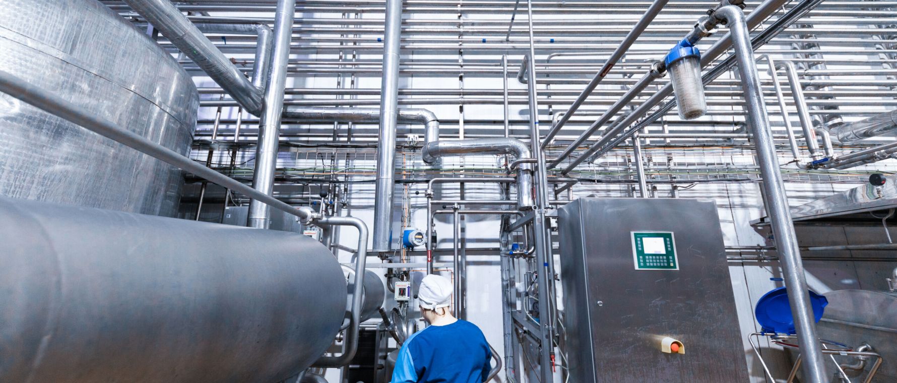 worker of production department make set up of the line while standing near equipment of dairy factory